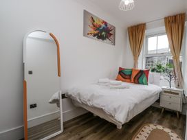 A bedroom with a bed, mirror and window at Aspen Boutique