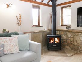 A living room with a stove and sofa at WEST LODGE in Ashford