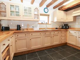 A kitchen with wooden cabinets and appliances at WEST LODGE Ashford
