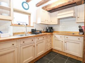 A kitchen with wooden cabinets and appliances at WEST LODGE Ashford