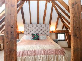 A bedroom with a bed and wooden beams at WEST LODGE Ashford
