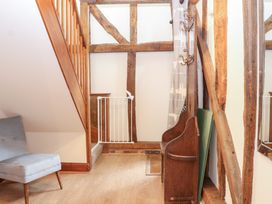 A hallway with a staircase and a chair at WEST LODGE in Ashford
