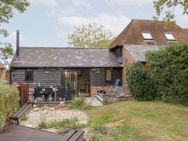 A garden view of a house with table and chairs at WEST LODGE in Ashford