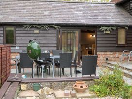 A garden area with a barbecue grill and dining set at WEST LODGE in Ashford