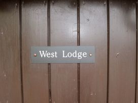 A sign displaying the name West Lodge on a wooden door