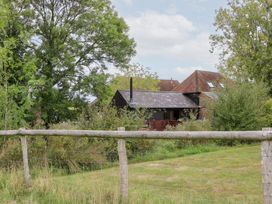 A house surrounded by trees and grass at WEST LODGE in Ashford