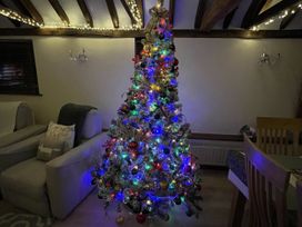 A Christmas tree in a living room at WEST LODGE in Kingsnorth