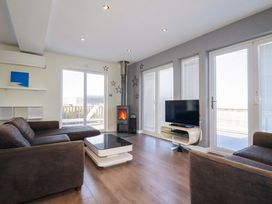 A living room with a stove and television at Gwel An Mor in Portreath
