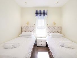A bedroom with two single beds and a window at Gwel An Mor in Portreath