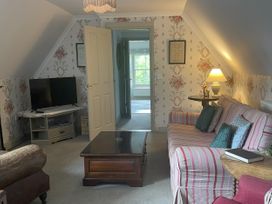 A sitting room with a television and coffee table at Butlers Loft in Par