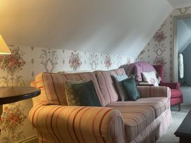 A living room with a striped sofa and side table at Butlers Loft in Par