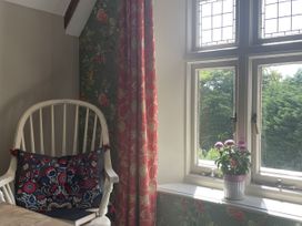 A chair with a cushion and flowerpot on a windowsill at Butlers Loft in Par