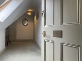A hallway with a door and a mirror at The Butler's Loft in Par
