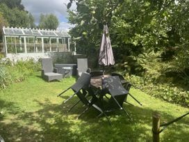 A garden with chairs and table at Butlers Loft in Par