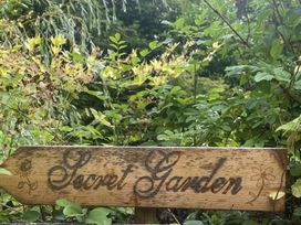 A wooden sign that says Secret Garden in an outdoor garden at Butlers Loft Par
