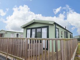 A caravan with a decking area at Sea Breeze C38 Dyffryn Seaside Estate Dyffryn Ardudwy