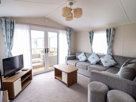 A living room with a sofa and television at Sea Breeze C38 Dyffryn Seaside Estate Dyffryn Ardudwy