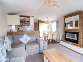 A living room with a sofa and dining table at Sea Breeze C38 Dyffryn Seaside Estate Dyffryn Ardudwy