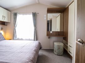 A bedroom with a bed and wardrobe at Sea Breeze C38 Dyffryn Seaside Estate Dyffryn Ardudwy