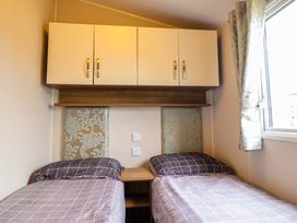 A bedroom with two beds and a cabinet at Sea Breeze C38 Dyffryn Seaside Estate Dyffryn Ardudwy