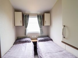 A bedroom with two single beds and wall cabinets at Sea Breeze C38 Dyffryn Seaside Estate Dyffryn Ardudwy
