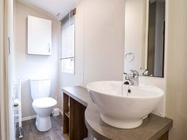 A bathroom with a toilet and sink at Sea Breeze C38 Dyffryn Seaside Estate Dyffryn Ardudwy