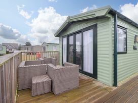 An outdoor seating area with a cabin at Sea Breeze C38 Dyffryn Seaside Estate Dyffryn Ardudwy