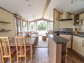 A living room with a dining area and kitchen at Beach Retreat E19 Dyffryn Seaside Estate Dyffryn Ardudwy