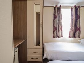 A bedroom with a bed and wardrobe at Beach Retreat E19 Dyffryn Seaside Estate Dyffryn Ardudwy