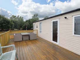 An outdoor seating area with table and chairs at Beach Retreat E19 Dyffryn Seaside Estate in Dyffryn Ardudwy
