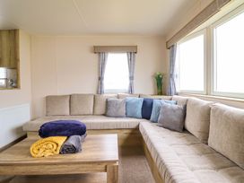 A living room with a sofa and coffee table at Beachcombers Barmouth Bay Holiday Park, Talybont