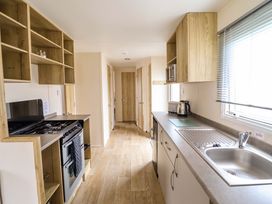 A kitchen with appliances and storage at Beachcombers Barmouth Bay Holiday Park in Talybont