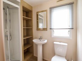 A bathroom with a shower, sink, and toilet at Beachcombers Barmouth Bay Holiday Park, Talybont