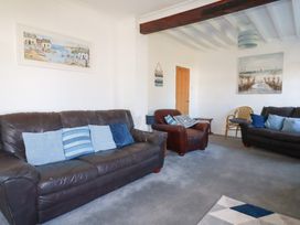 A living room with sofas and an art piece at Tregundy Farmhouse in Perranporth