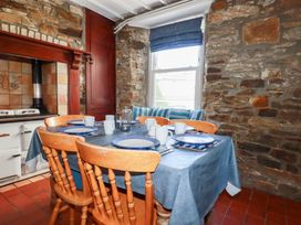 A dining room with a table set for meals at Tregundy Farmhouse in Perranporth