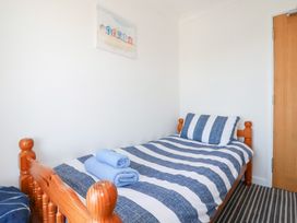 A bedroom with a single bed and towels at Tregundy Farmhouse in Perranporth
