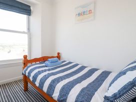 A bedroom with a bed and towel on it at Tregundy Farmhouse Perranporth