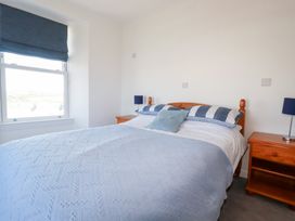 A bedroom with a bed and bedside tables at Tregundy Farmhouse in Perranporth