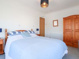 A bedroom with a bed and wardrobe at Tregundy Farmhouse in Perranporth