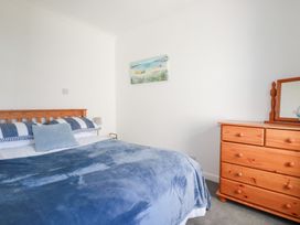 A bedroom with a bed and dresser at Tregundy Farmhouse Perranporth