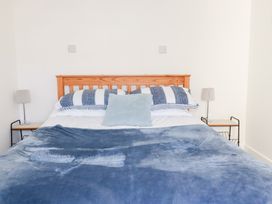 A bedroom with a bed and bedside table at Tregundy Farmhouse in Perranporth