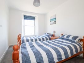 A bedroom with two beds and a window at Tregundy Farmhouse in Perranporth