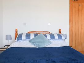 A bedroom with a bed and bedside lamp at Tregundy Farmhouse Perranporth