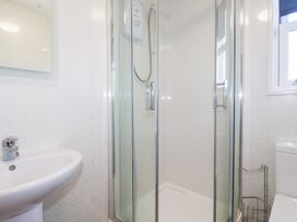 A bathroom with a shower and sink at Tregundy Farmhouse Perranporth