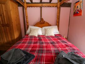 A bedroom with a wooden bed and wardrobe at The Little Laura Ashley House in Machynlleth