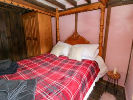 A bedroom with a bed and wardrobe at The Little Laura Ashley House in Machynlleth