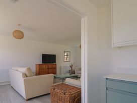 A living room with a television and seating area at Oakwood in Chideock