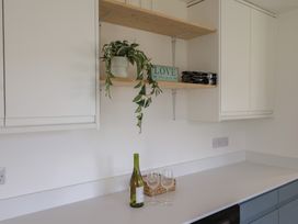 A kitchen with a wine bottle and glasses on the countertop at Oakwood in Chideock