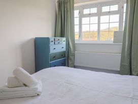 A bedroom with a bed and dresser at Oakwood in Chideock