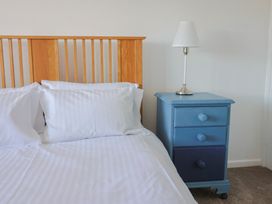 A bedroom with a bed and a blue bedside table at Oakwood in Chideock